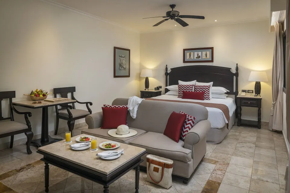 Deluxe Junior Suite garden-view room with king bed and sofa at Valentin Imperial Riviera Maya.