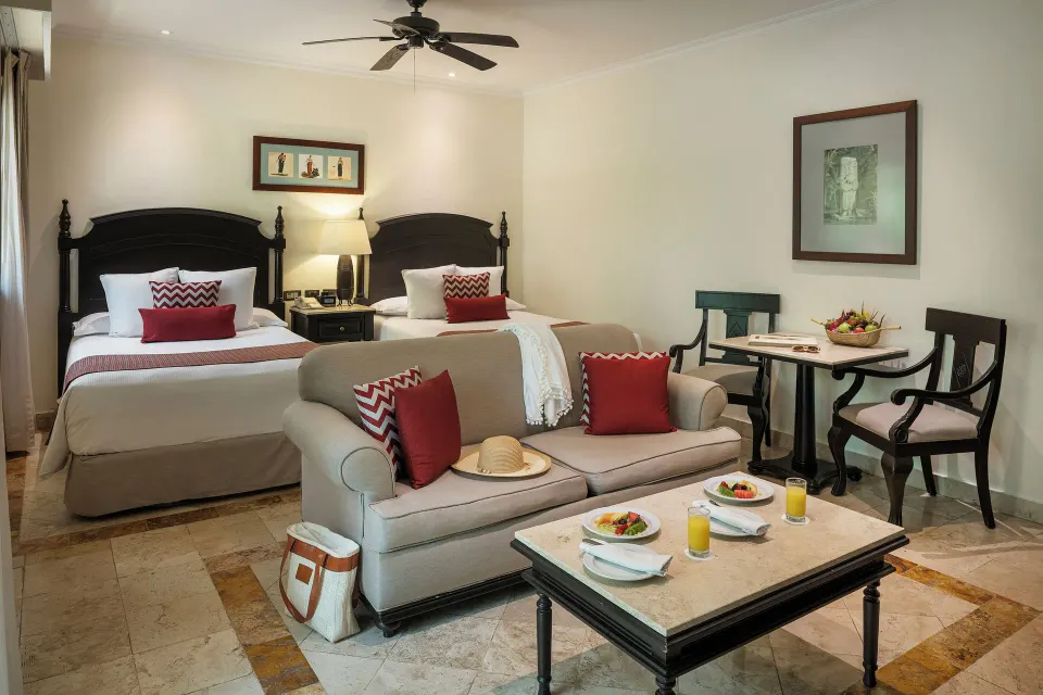 Deluxe Junior Suite garden-view room with two beds and breakfast table at Valentin Imperial Riviera Maya.
