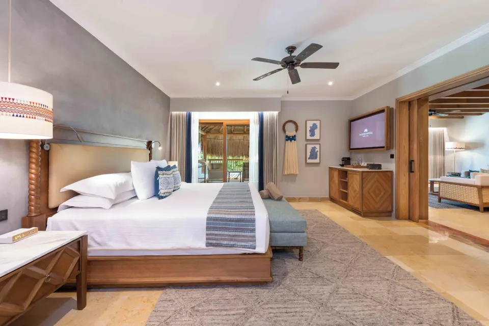 Diamond Suite bedroom with king bed, TV, and living room entry at Valentin Imperial Riviera Maya.