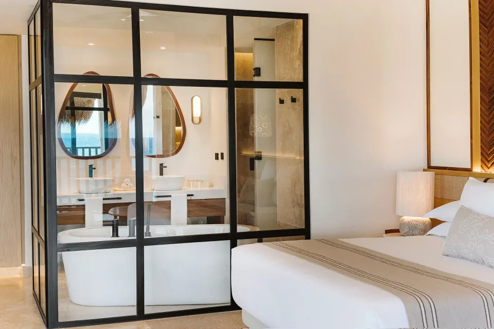 Dunas Private Pool Ocean View Suite bed and glass bathroom tub at Valentin Imperial Riviera Maya.