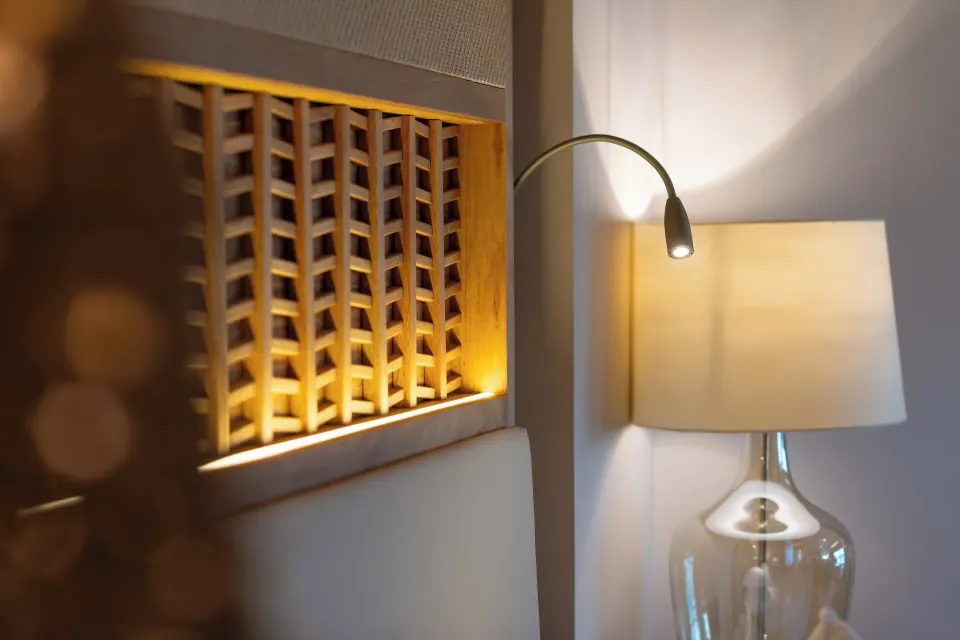 Emerald Junior Suite bedside lamps and wood headboard at Valentin Imperial Riviera Maya.