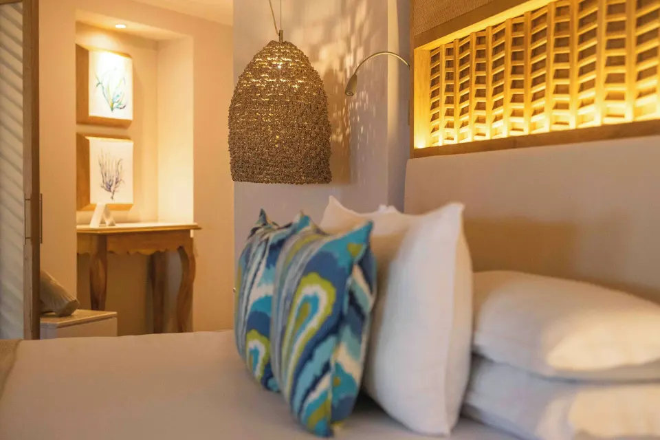 Emerald Junior Suite bed pillows and pendant light at Valentin Imperial Riviera Maya.