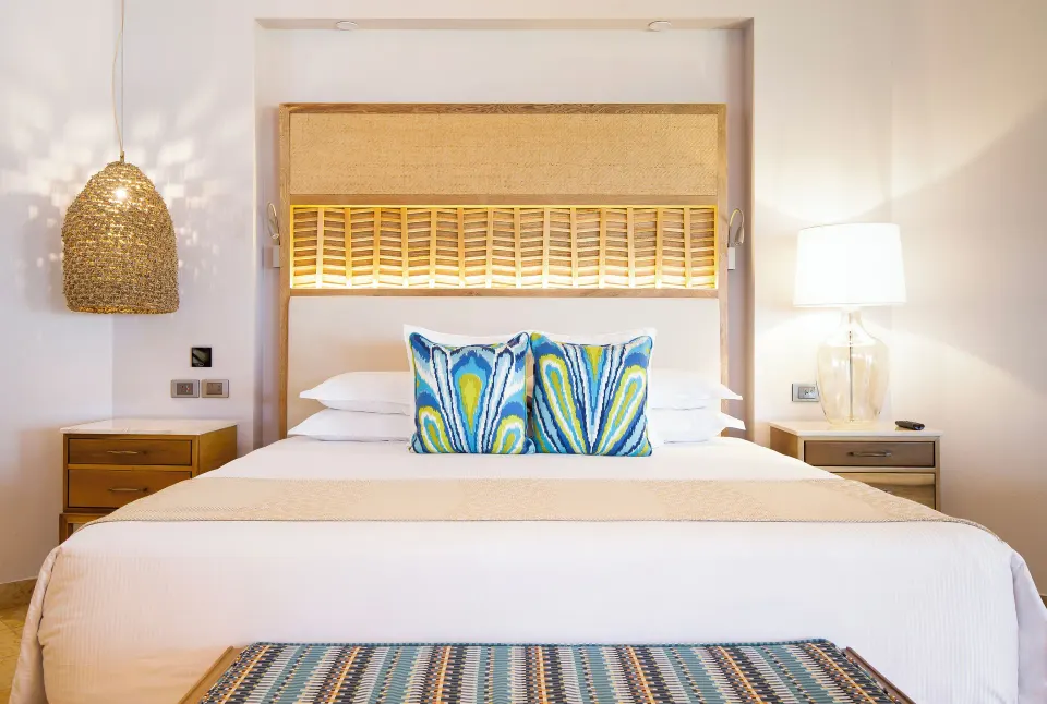 Emerald Junior Suite bed with woven headboard at Valentin Imperial Riviera Maya.