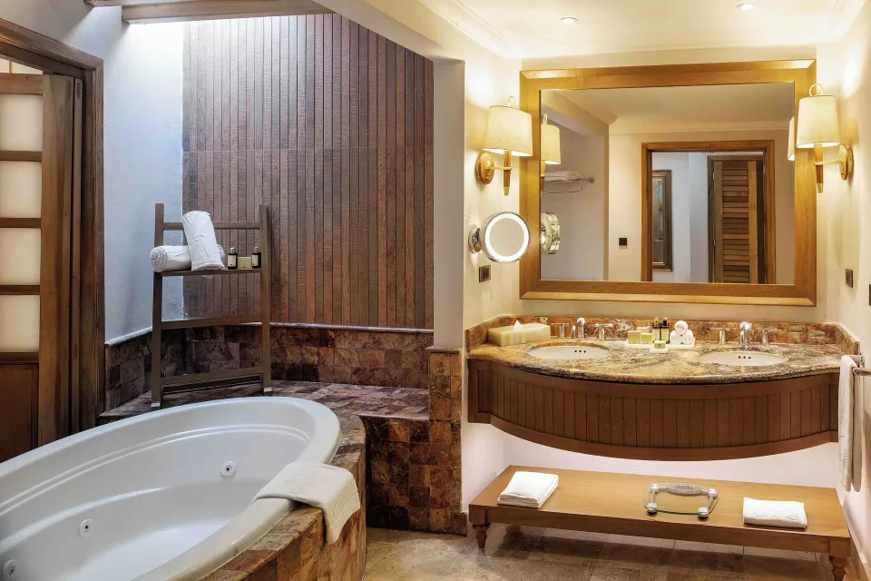 Golden Junior Suite bathroom with tub and double vanity at Valentin Imperial Riviera Maya.