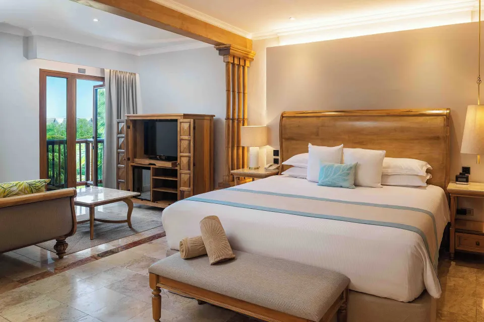 Golden Junior Suite king bed with balcony doors at Valentin Imperial Riviera Maya.