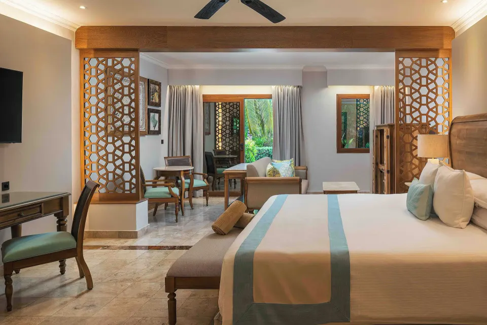 Golden Junior Suite king bed and sitting area at Valentin Imperial Riviera Maya.