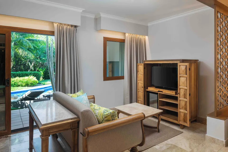 Golden Junior Suite lounge with TV cabinet and terrace access at Valentin Imperial Riviera Maya.