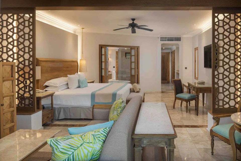 Golden Junior Suite king bed viewed from the lounge at Valentin Imperial Riviera Maya.