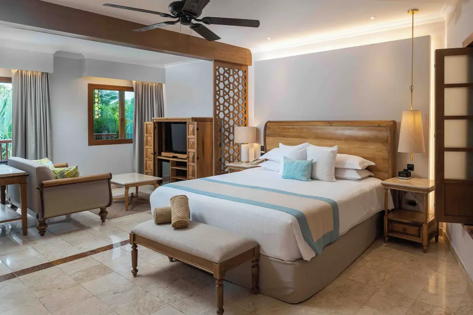 Golden Superior Junior Suite king bed and sitting area at Valentin Imperial Riviera Maya.