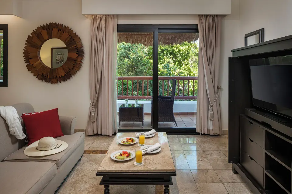 Silver Junior Suite sitting area with balcony and TV at Valentin Imperial Riviera Maya.