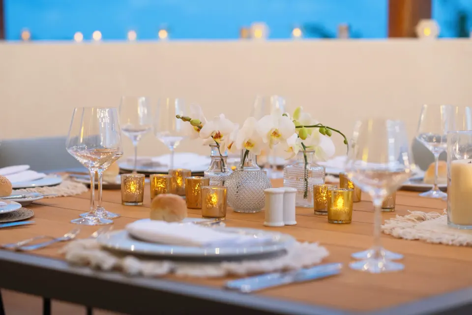Suite Imperial Privé dining table with candles and orchids at Valentin Imperial Riviera Maya.
