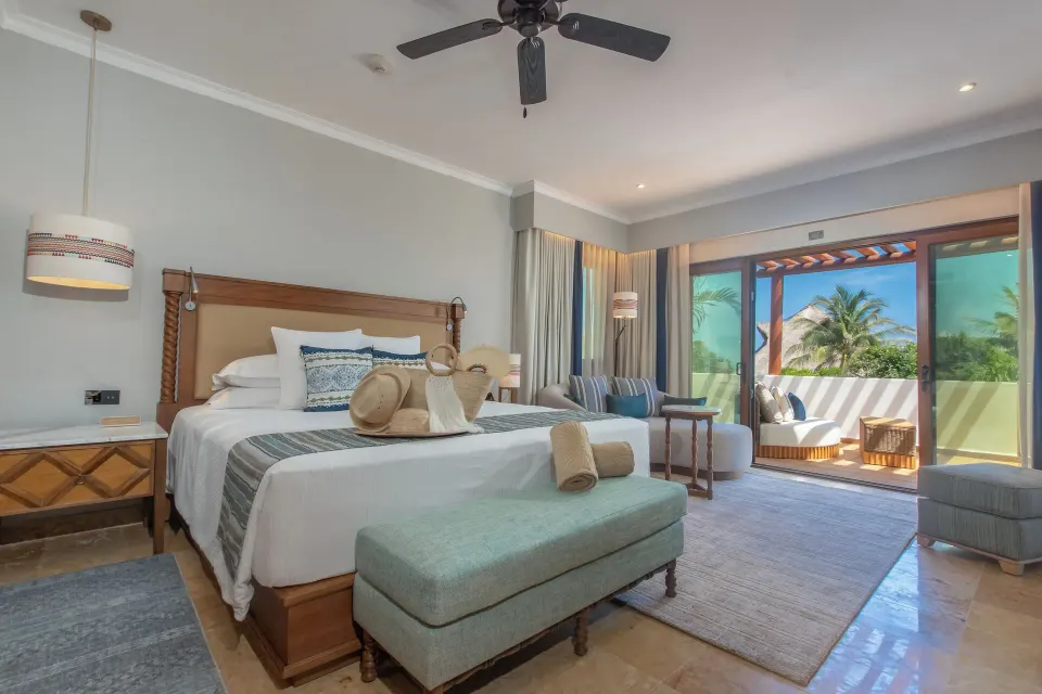 Suite Imperial Privé king bedroom with balcony seating at Valentin Imperial Riviera Maya.
