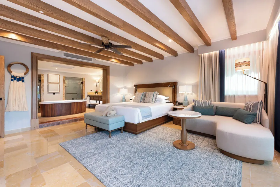 Suite Imperial Privé king bed, sofa, and open bath area at Valentin Imperial Riviera Maya.