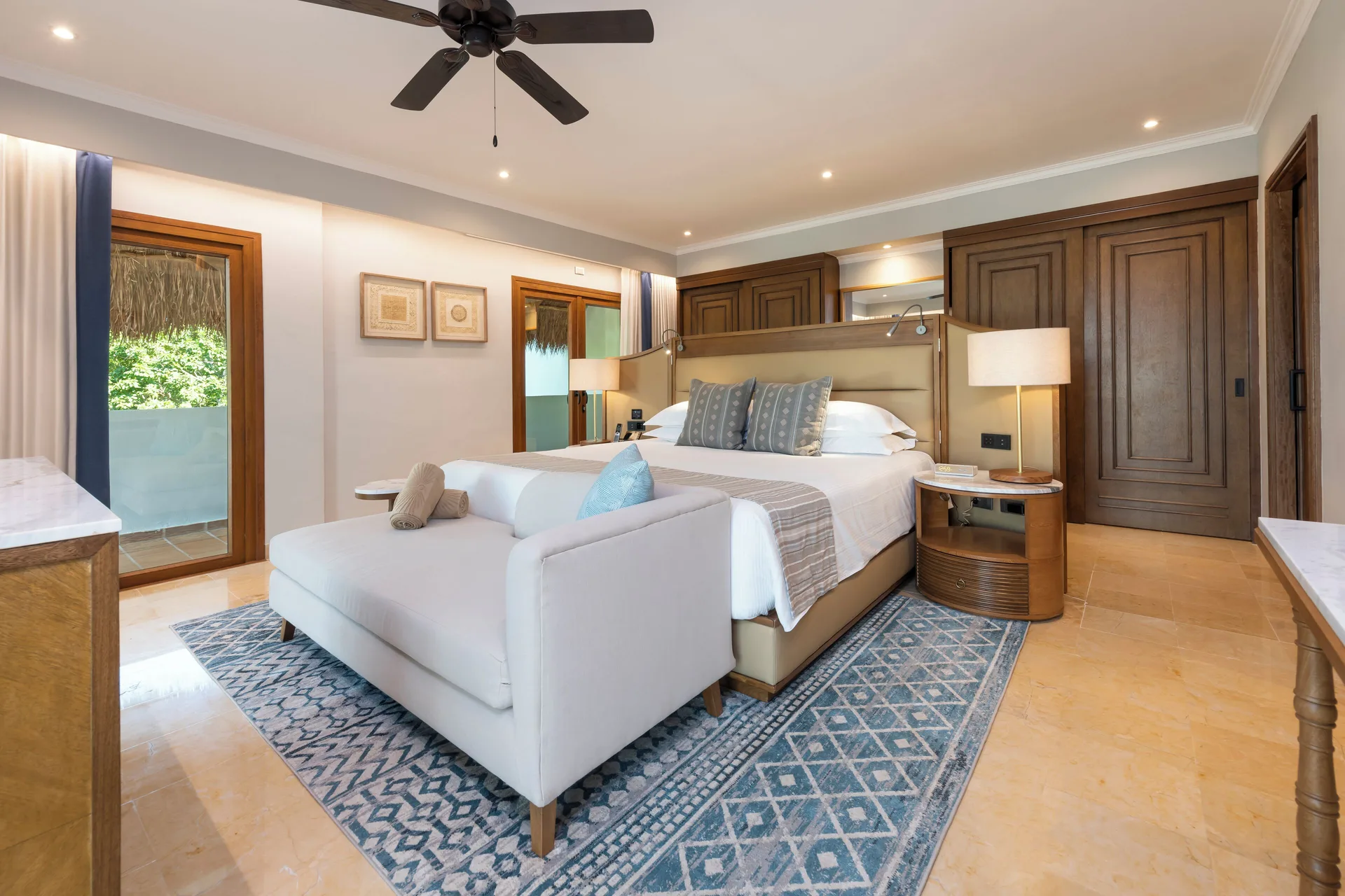 Onyx Honeymoon Suite king bed, sofa, and balcony doors at Valentin Imperial Riviera Maya.