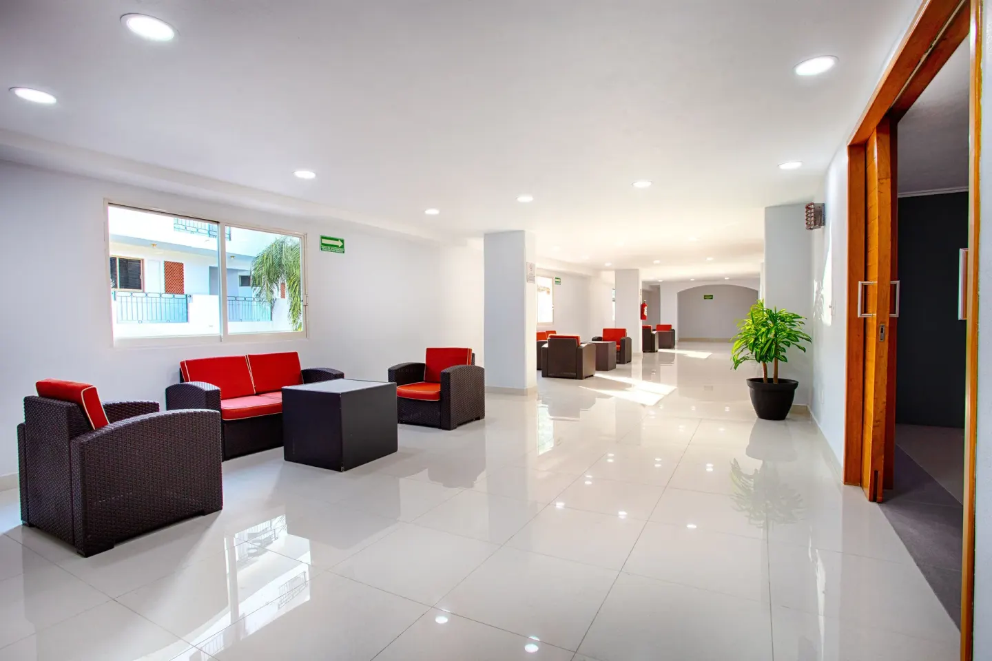 A bright lounge area with red seating lines a hallway at Vamar Vallarta Marina and Beach Resort.