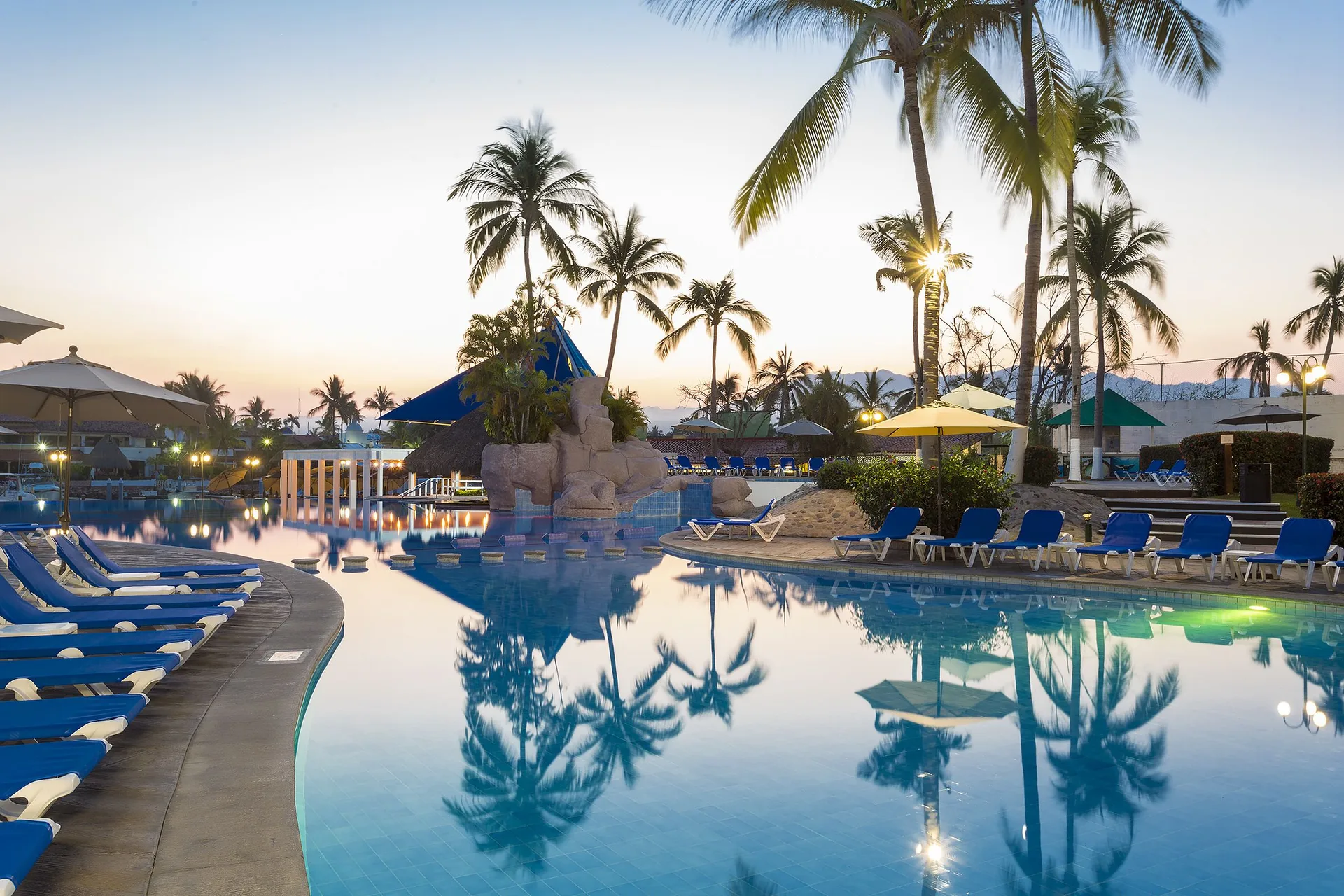 Curved resort pool with blue loungers at Vamar Vallarta Marina and Beach Resort.