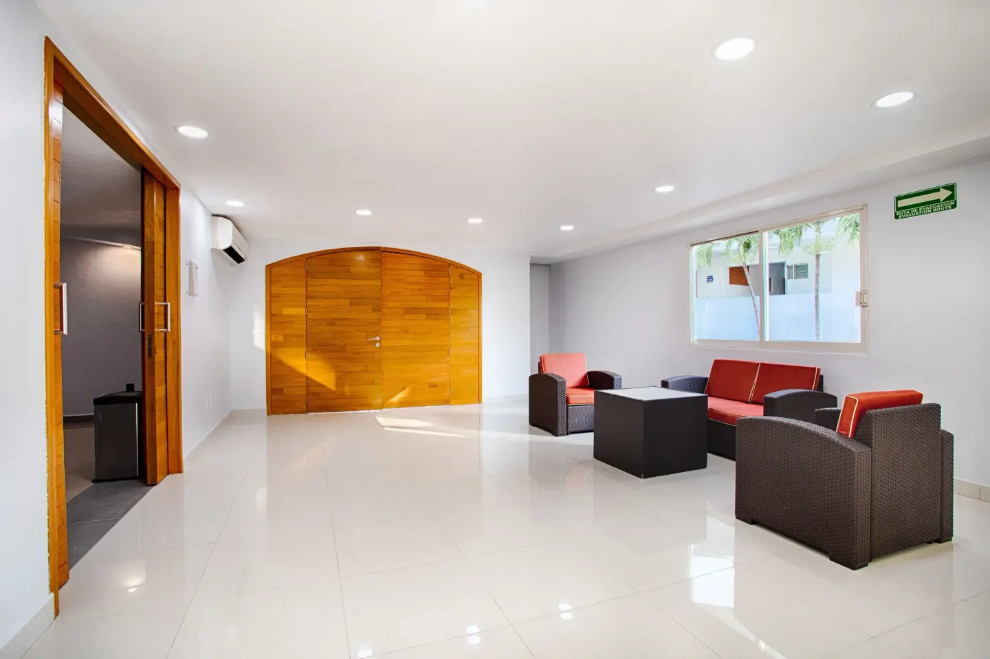 A lounge seating nook with red cushions sits near wooden doors at Vamar Vallarta Marina and Beach Resort.