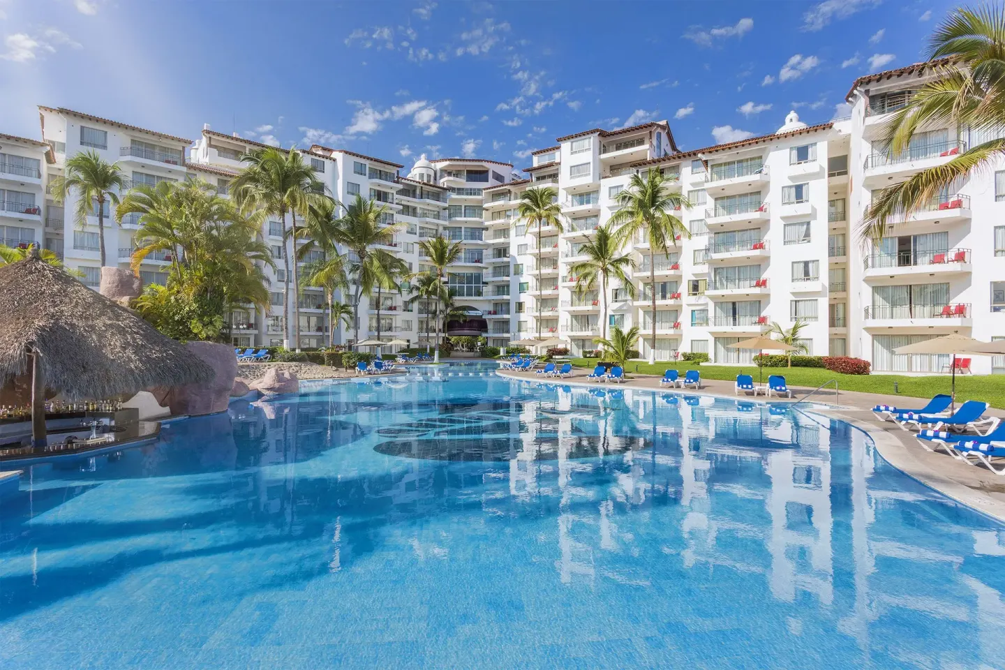 Large resort pool with loungers and white buildings at Vamar Vallarta Marina and Beach Resort.