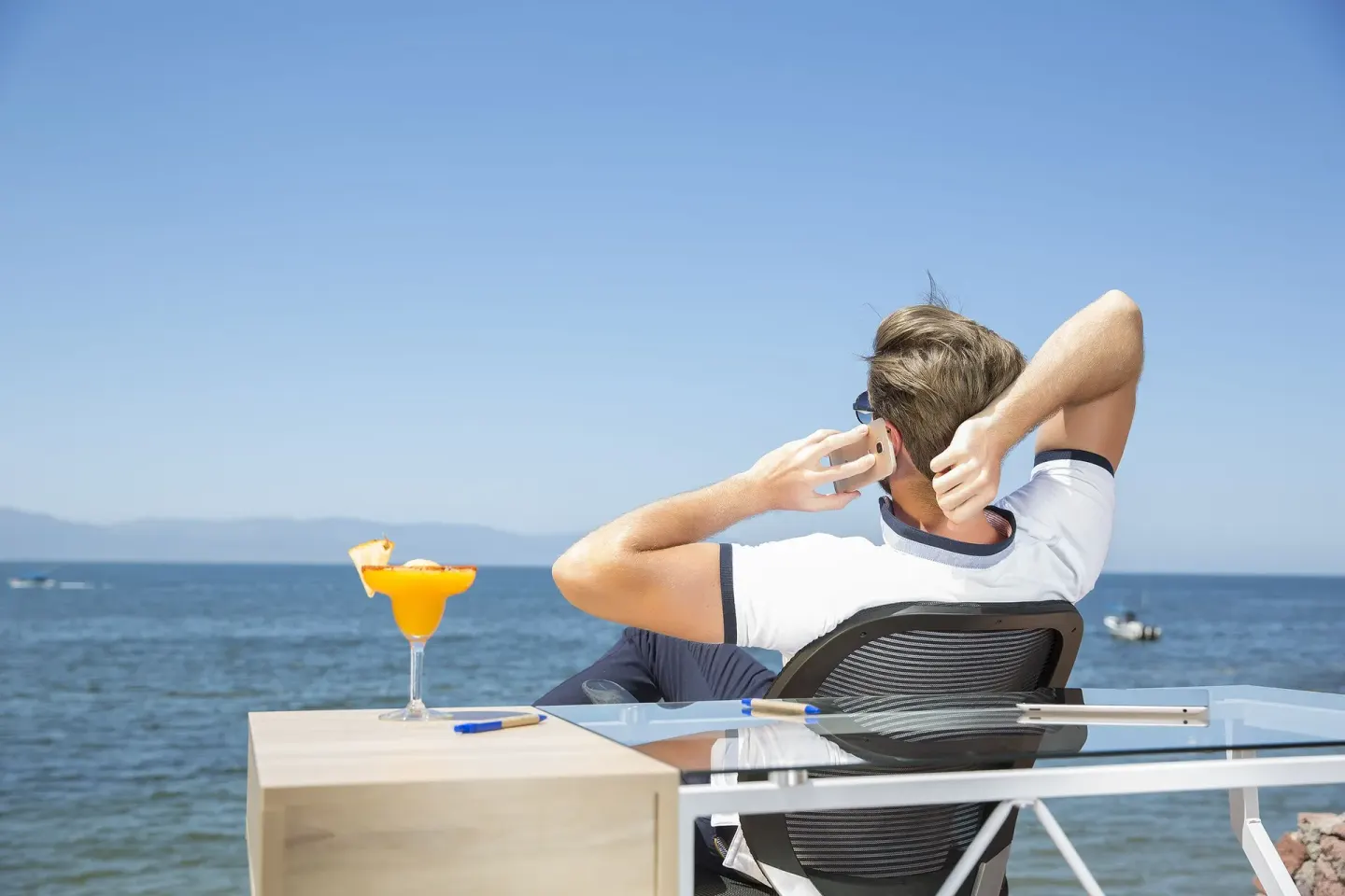 Guest relaxing by the ocean with a cocktail at Vamar Vallarta Marina and Beach Resort.