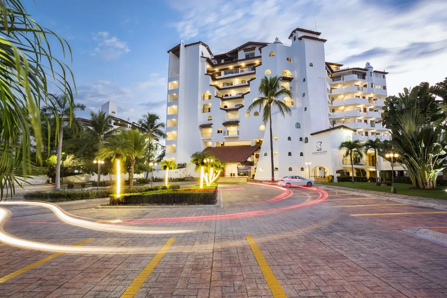 Illuminated resort entrance and tower at dusk at Vamar Vallarta Marina and Beach Resort.