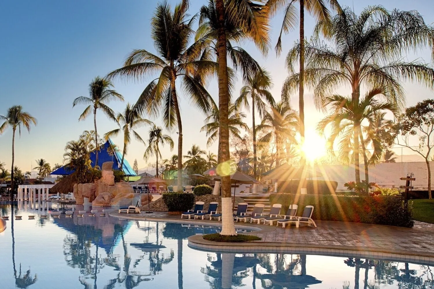 Palm-lined pool at sunset at Vamar Vallarta Marina and Beach Resort.