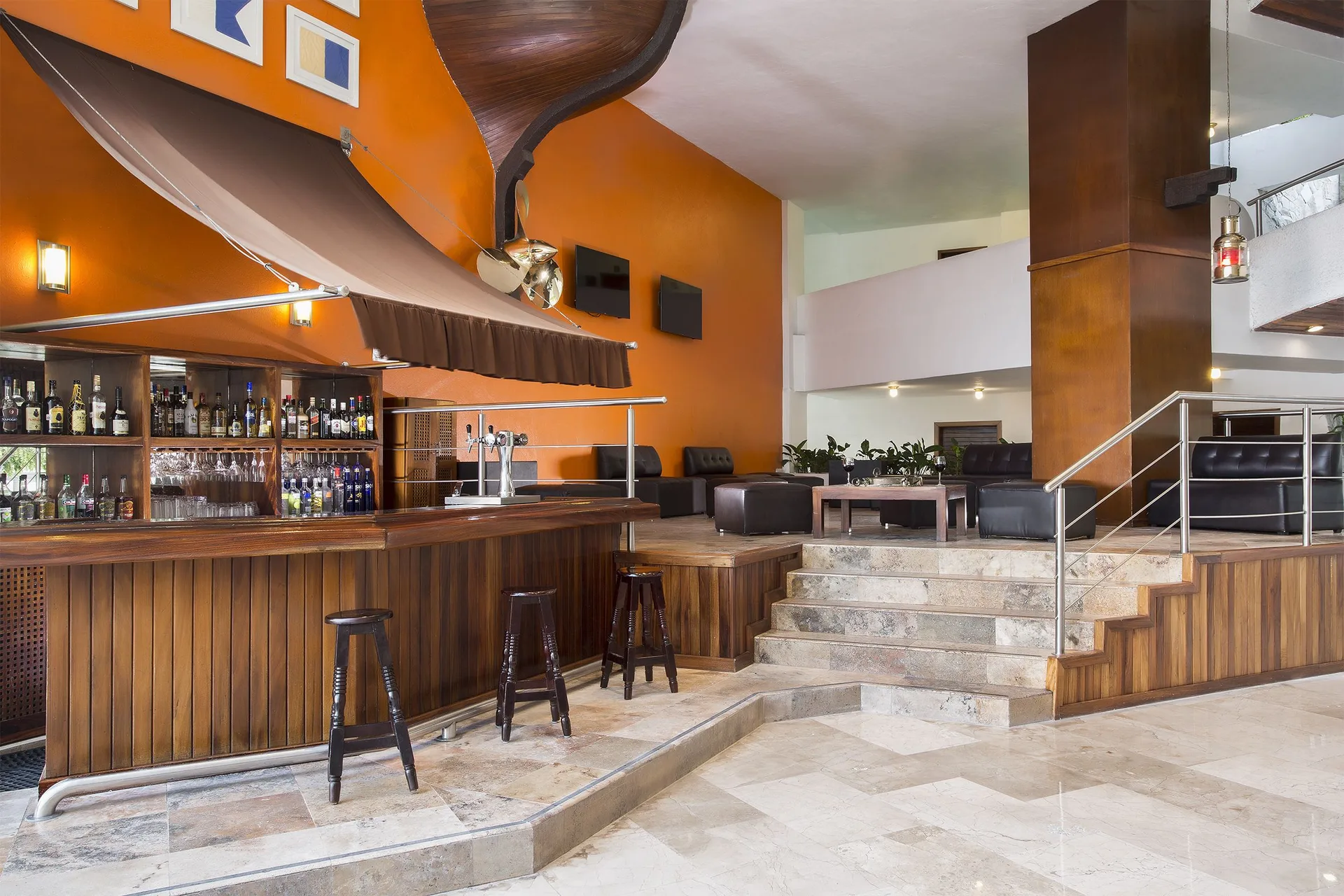 Lobby bar with wood counter and lounge seating at Vamar Vallarta Marina and Beach Resort.
