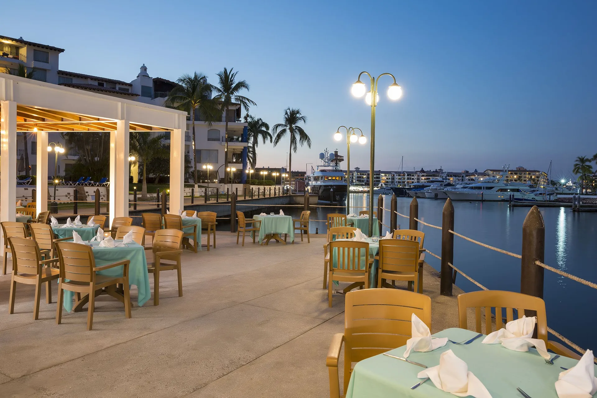 Marina-side outdoor dining at dusk at Vamar Vallarta Marina and Beach Resort.