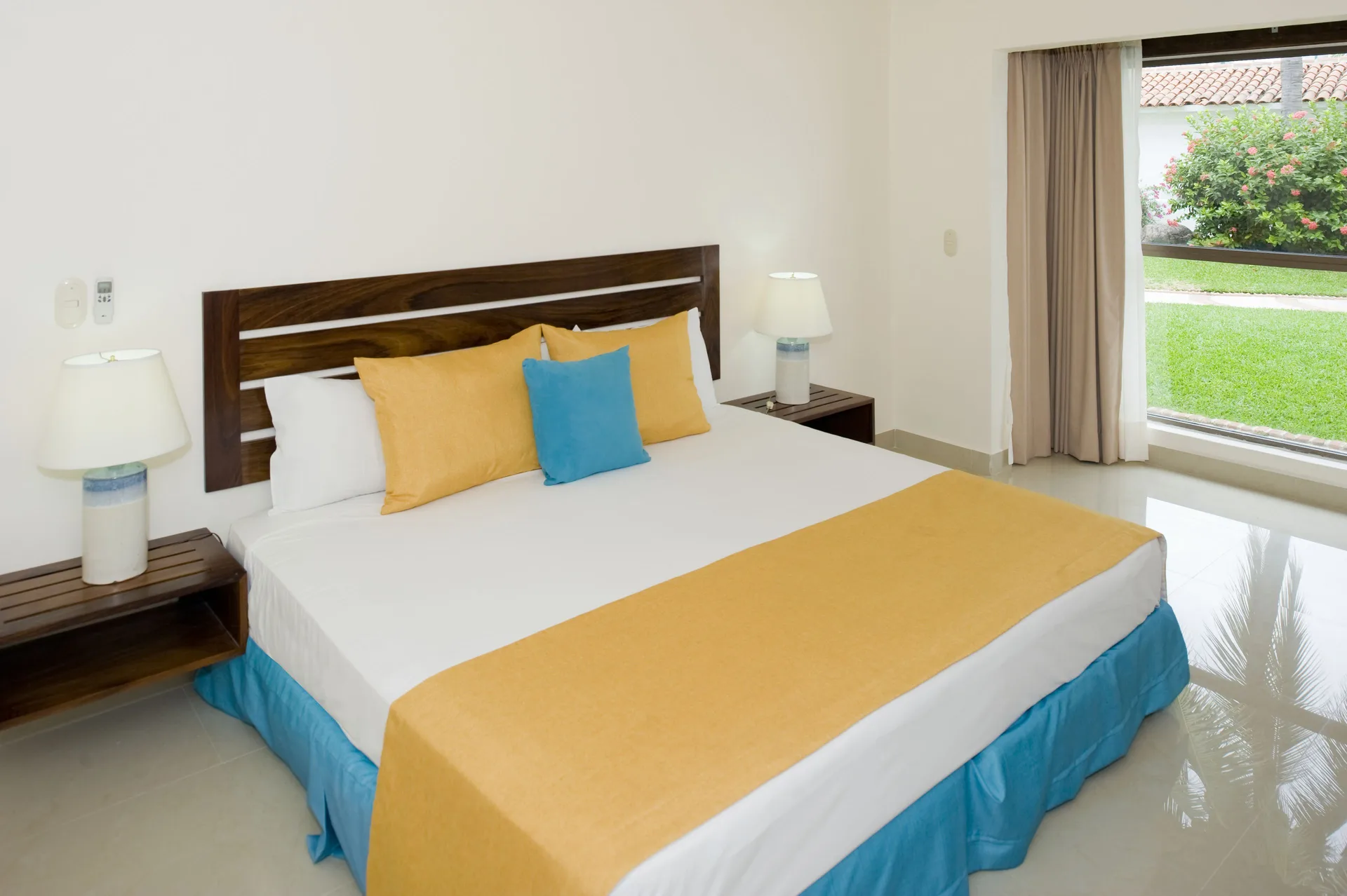 One Bedroom Villa king bed with garden-facing window at Vamar Vallarta Marina and Beach Resort.