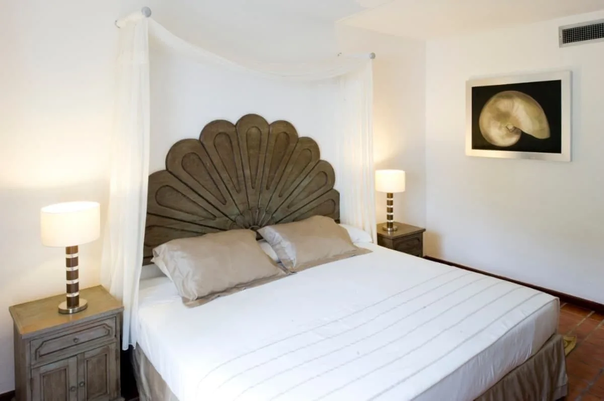 One Bedroom Villa king bed with shell wall art at Vamar Vallarta Marina and Beach Resort.