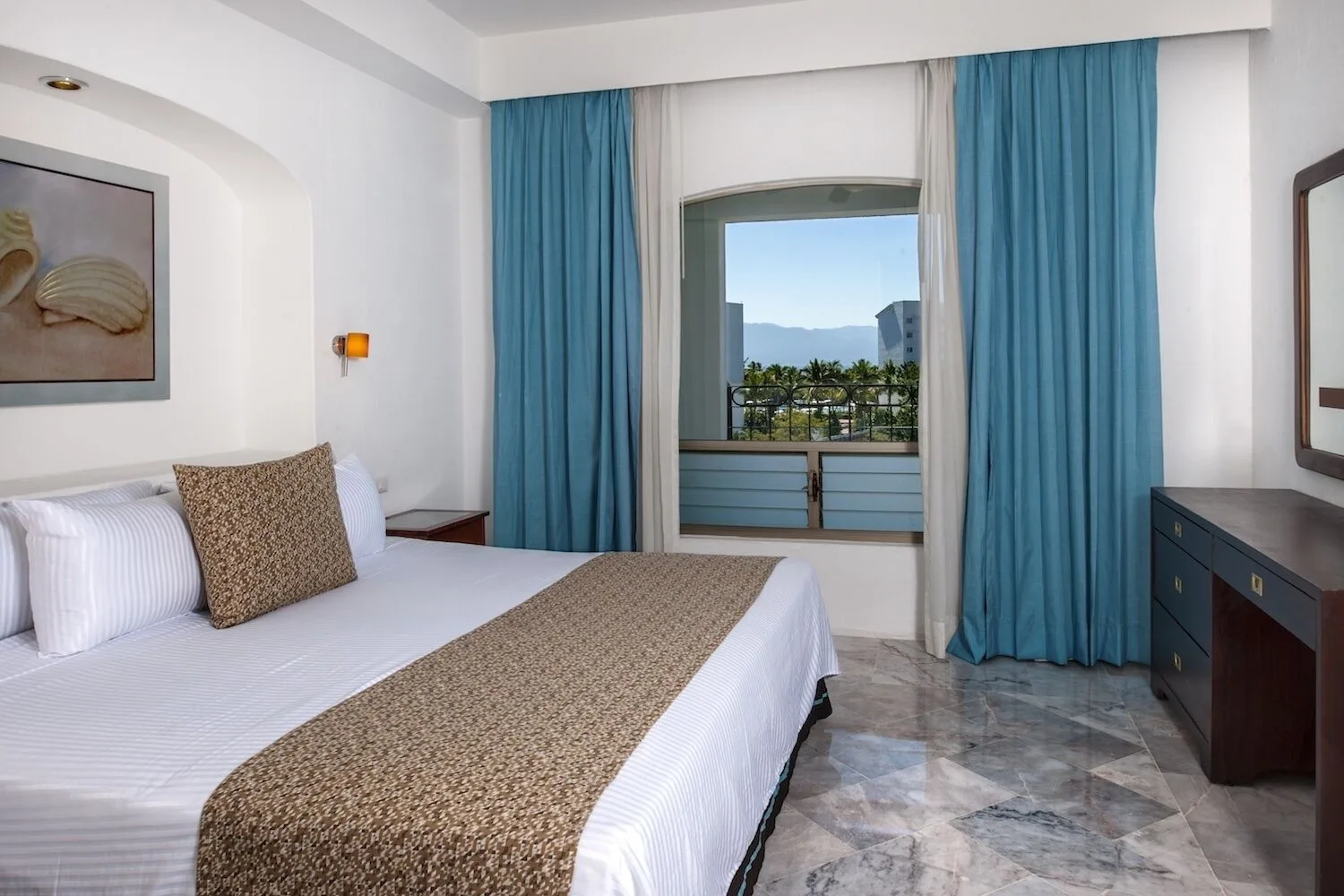 Standard king room with dresser and balcony view at Vamar Vallarta Marina and Beach Resort.