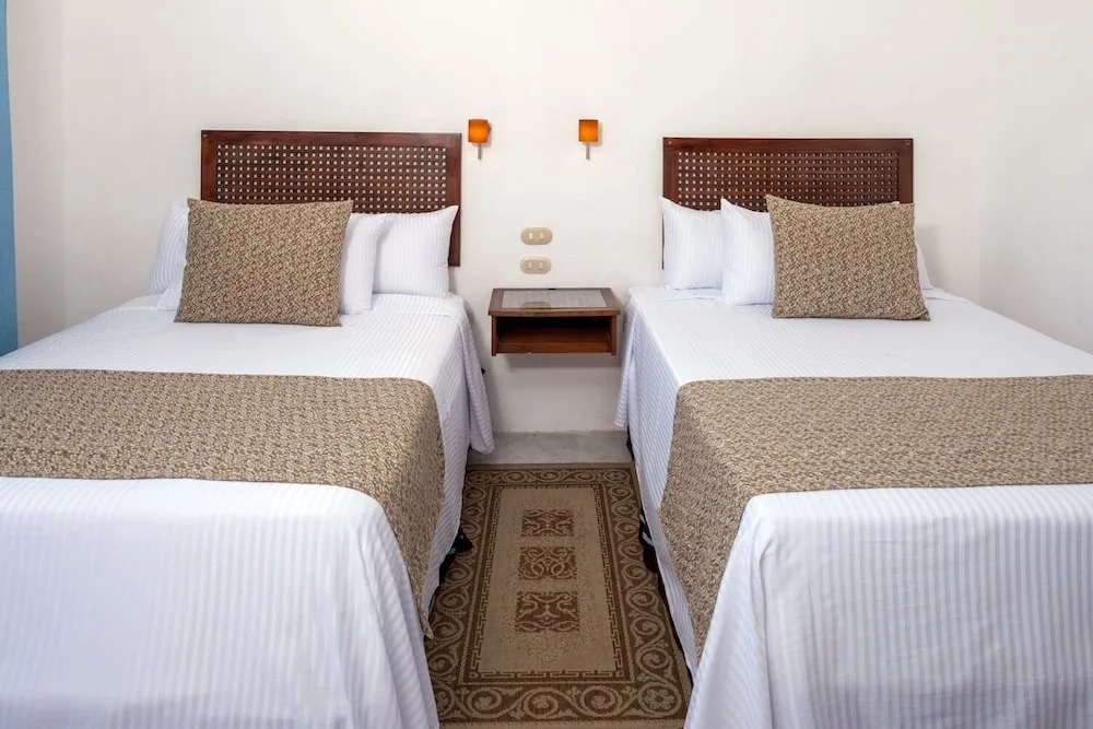 Standard room two-bed setup with woven headboards at Vamar Vallarta Marina and Beach Resort.