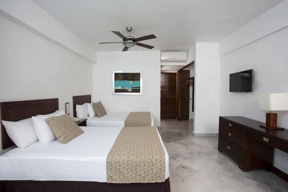 Standard room with two double beds, desk, TV, and ceiling fan at Vamar Vallarta Marina and Beach Resort.