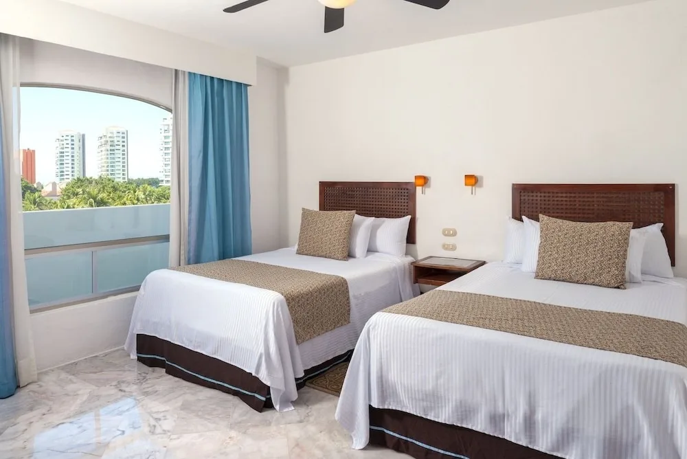 Standard room with two double beds and balcony window at Vamar Vallarta Marina and Beach Resort.
