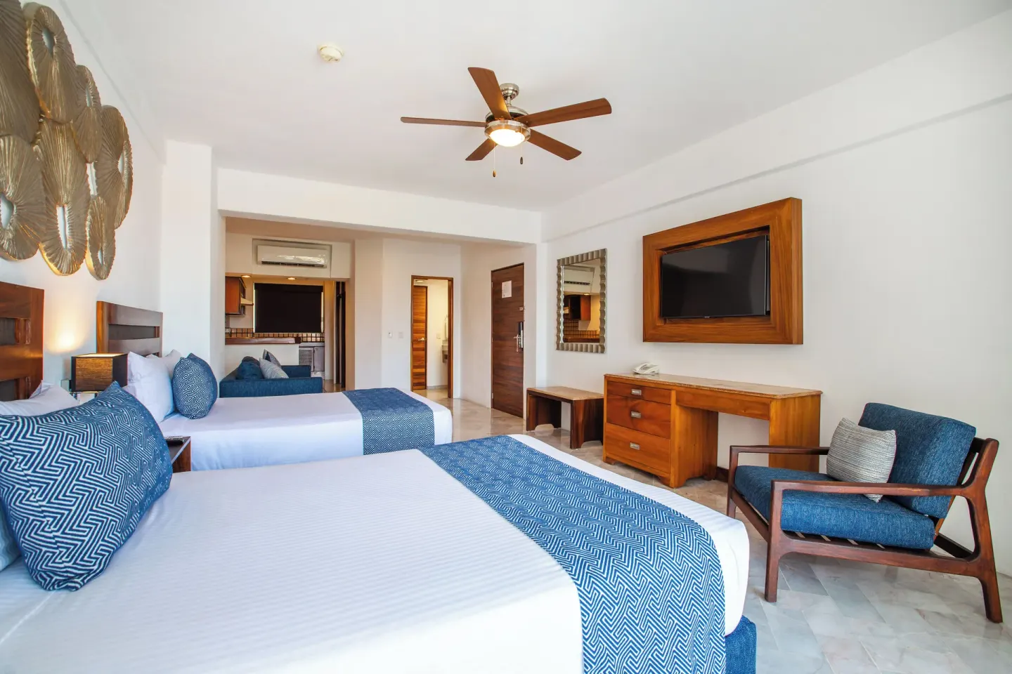Superior Con Balcón room with two beds and sitting chair at Vamar Vallarta Marina and Beach Resort.