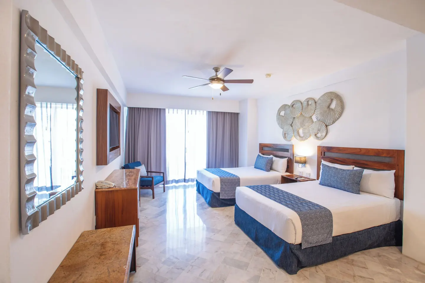 Superior Con Balcón room with two beds and wall mirror at Vamar Vallarta Marina and Beach Resort.