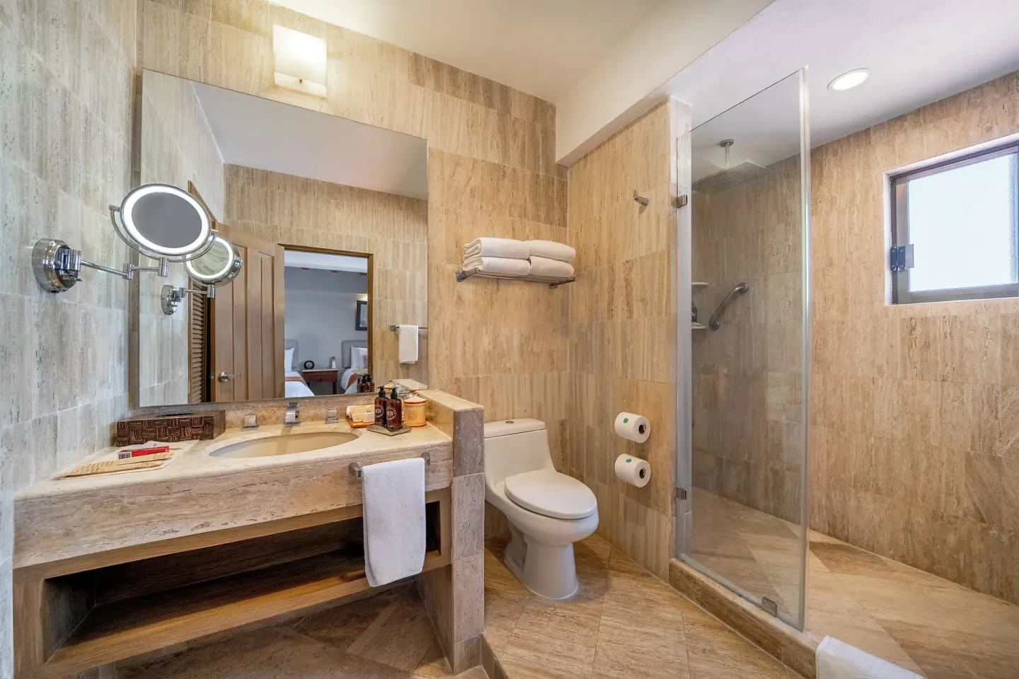 Bathroom with vanity, toilet, and glass shower at Velas Vallarta Suites Resort.