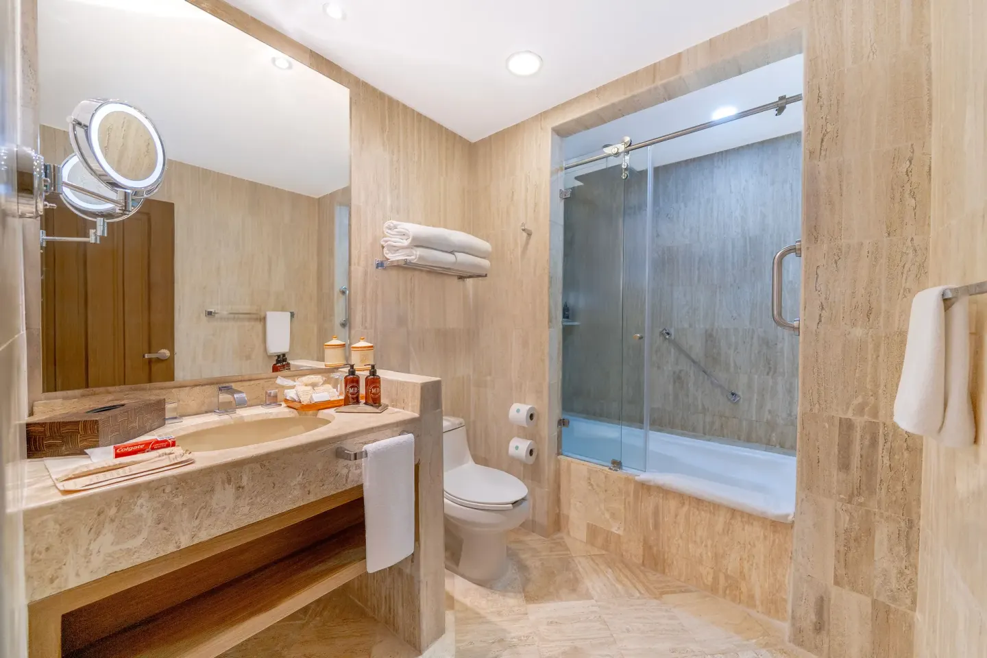 Bathroom with tub-shower and stone vanity at Velas Vallarta Suites Resort.