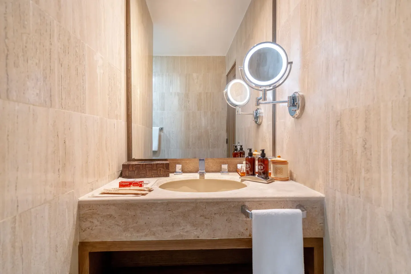 Stone bathroom vanity with lighted mirror at Velas Vallarta Suites Resort.