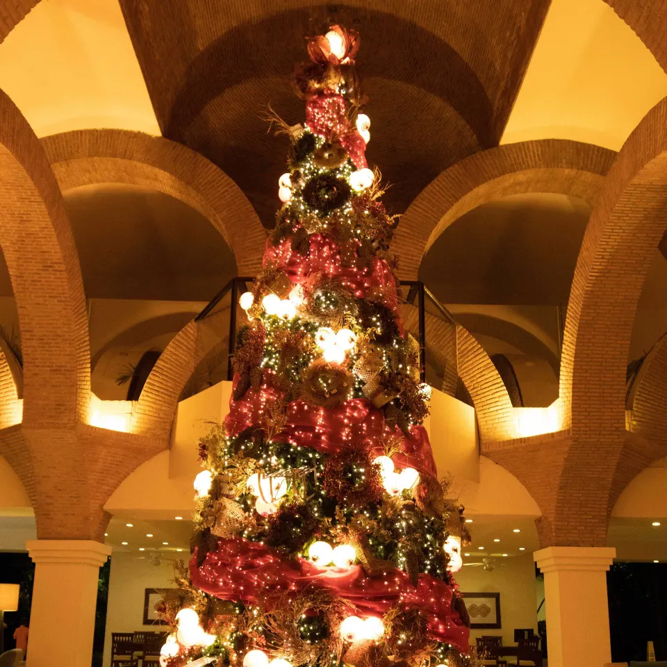 Decorated Christmas tree framed by lobby arches at Velas Vallarta Suites Resort.