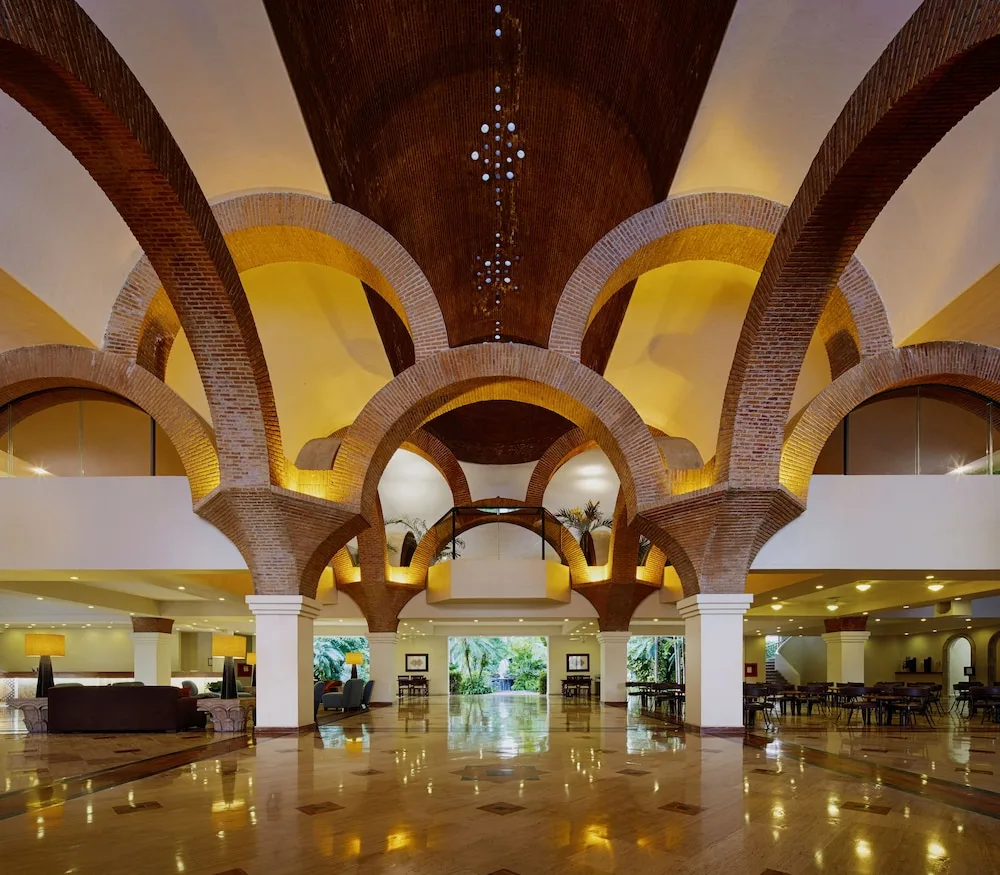 Grand lobby with brick arches and polished floors at Velas Vallarta Suites Resort.