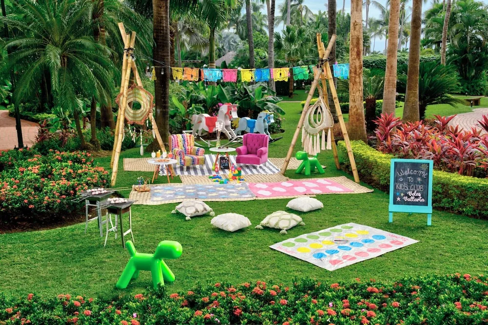 Kids club lawn setup with games and colorful seating at Velas Vallarta Suites Resort.