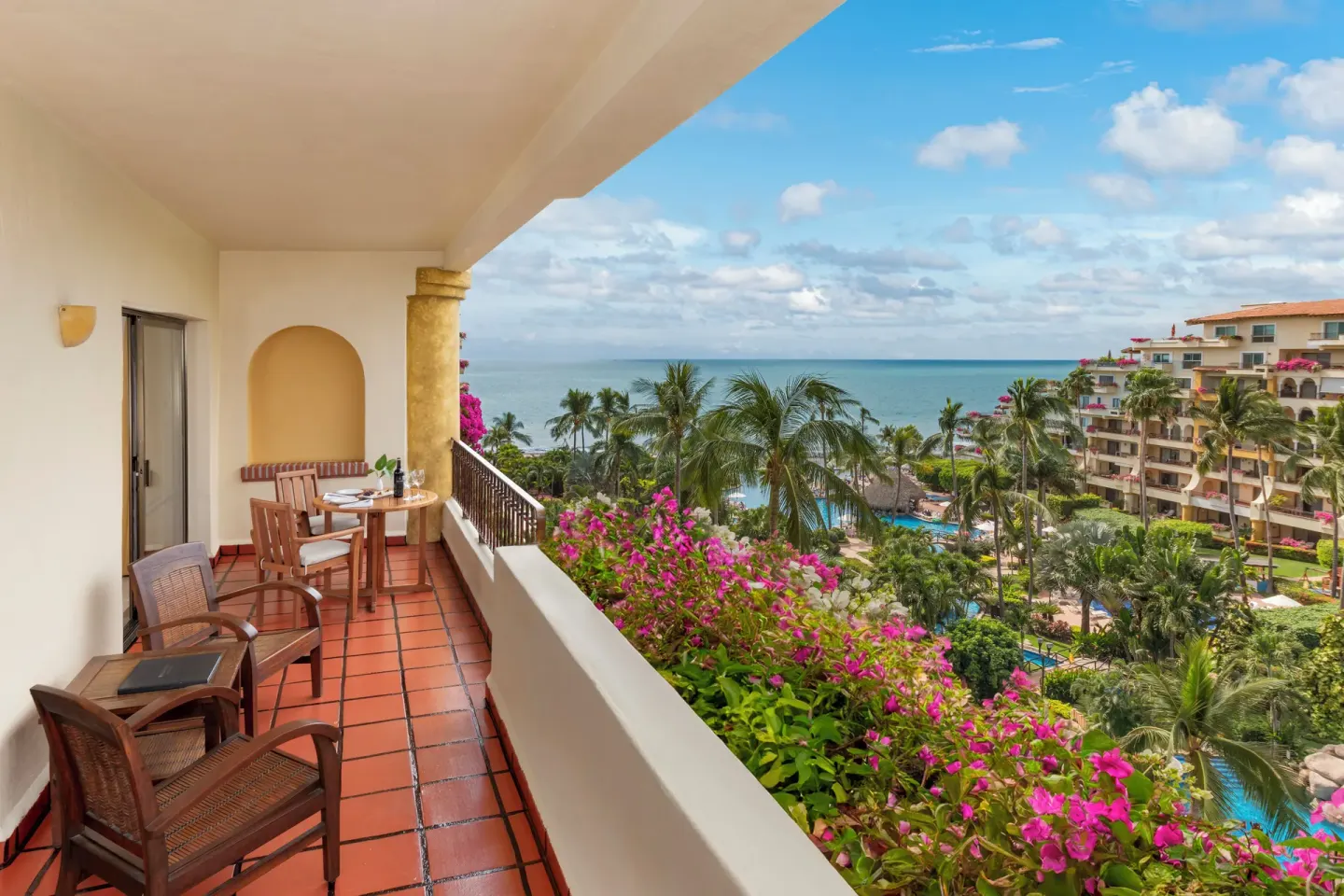 Large ocean-view balcony with dining table at Velas Vallarta Suites Resort.