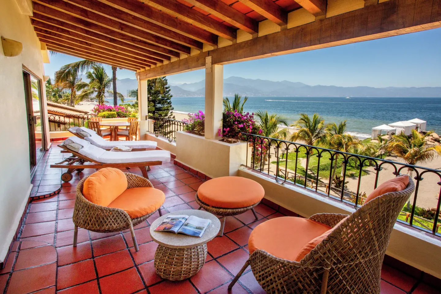Oceanfront terrace with loungers and wicker chairs at Velas Vallarta Suites Resort.