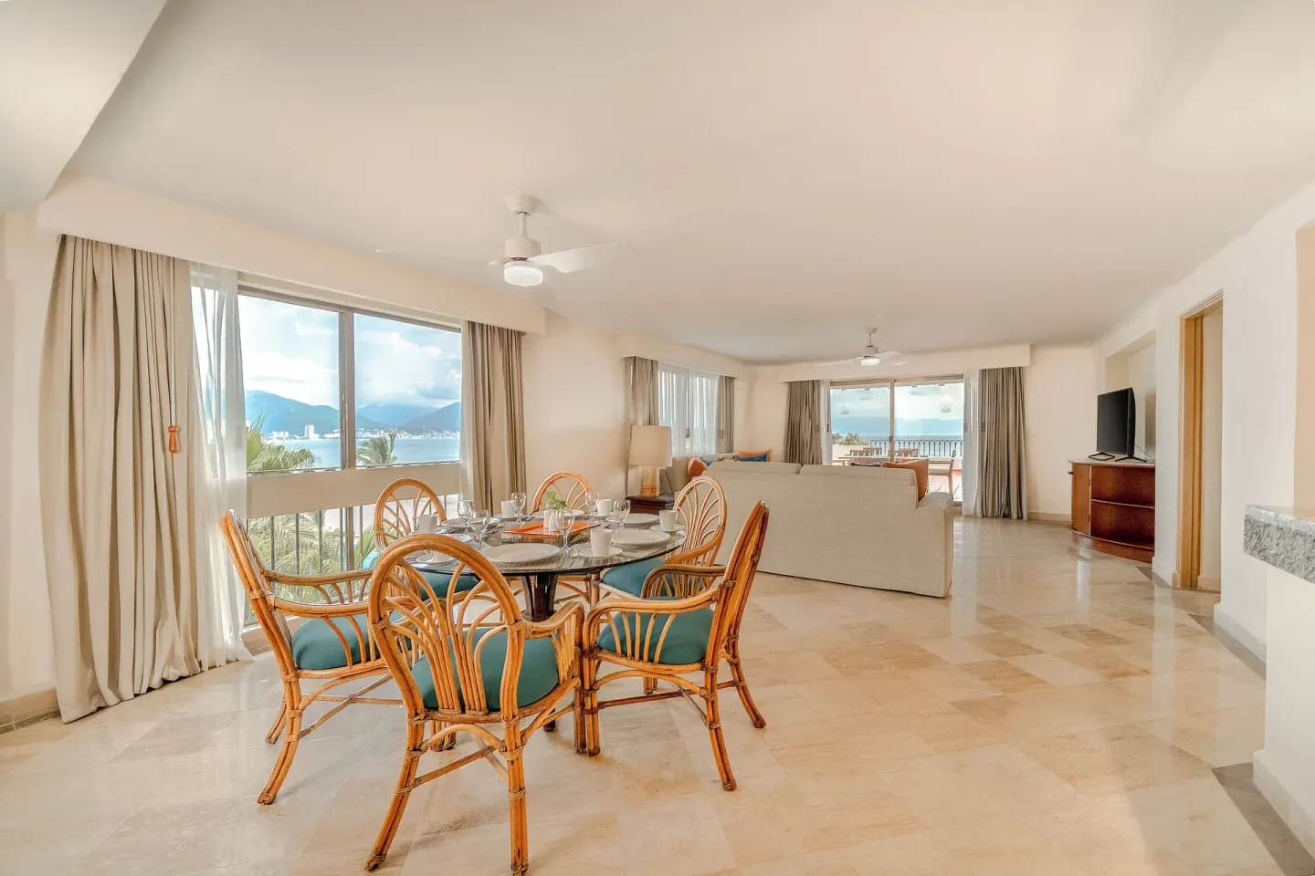 Spacious suite dining and lounge area with bay views at Velas Vallarta Suites Resort.