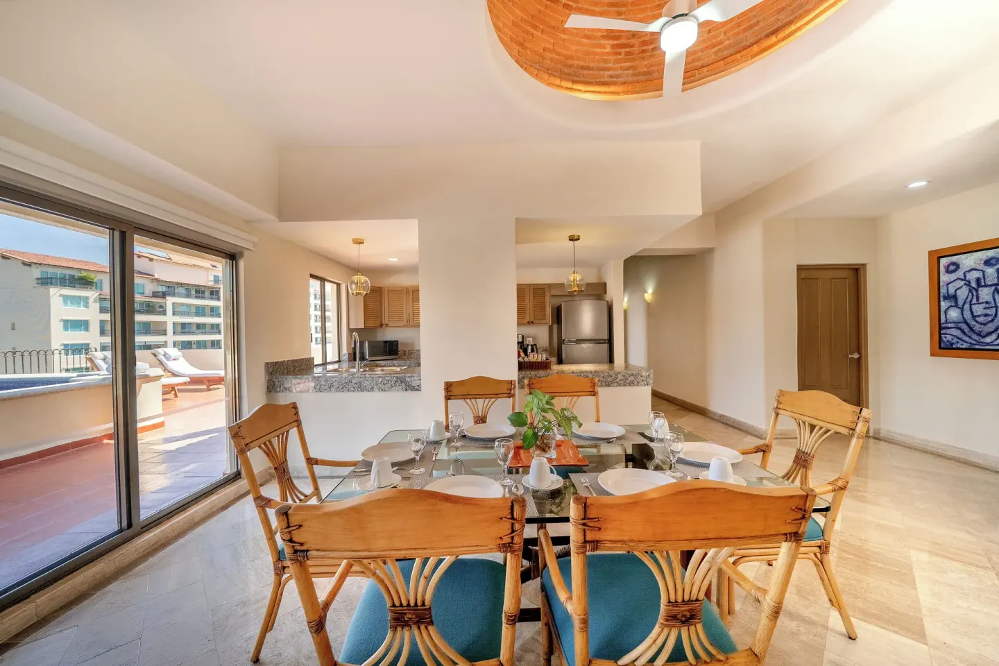 Suite dining table beside kitchen and terrace doors at Velas Vallarta Suites Resort.