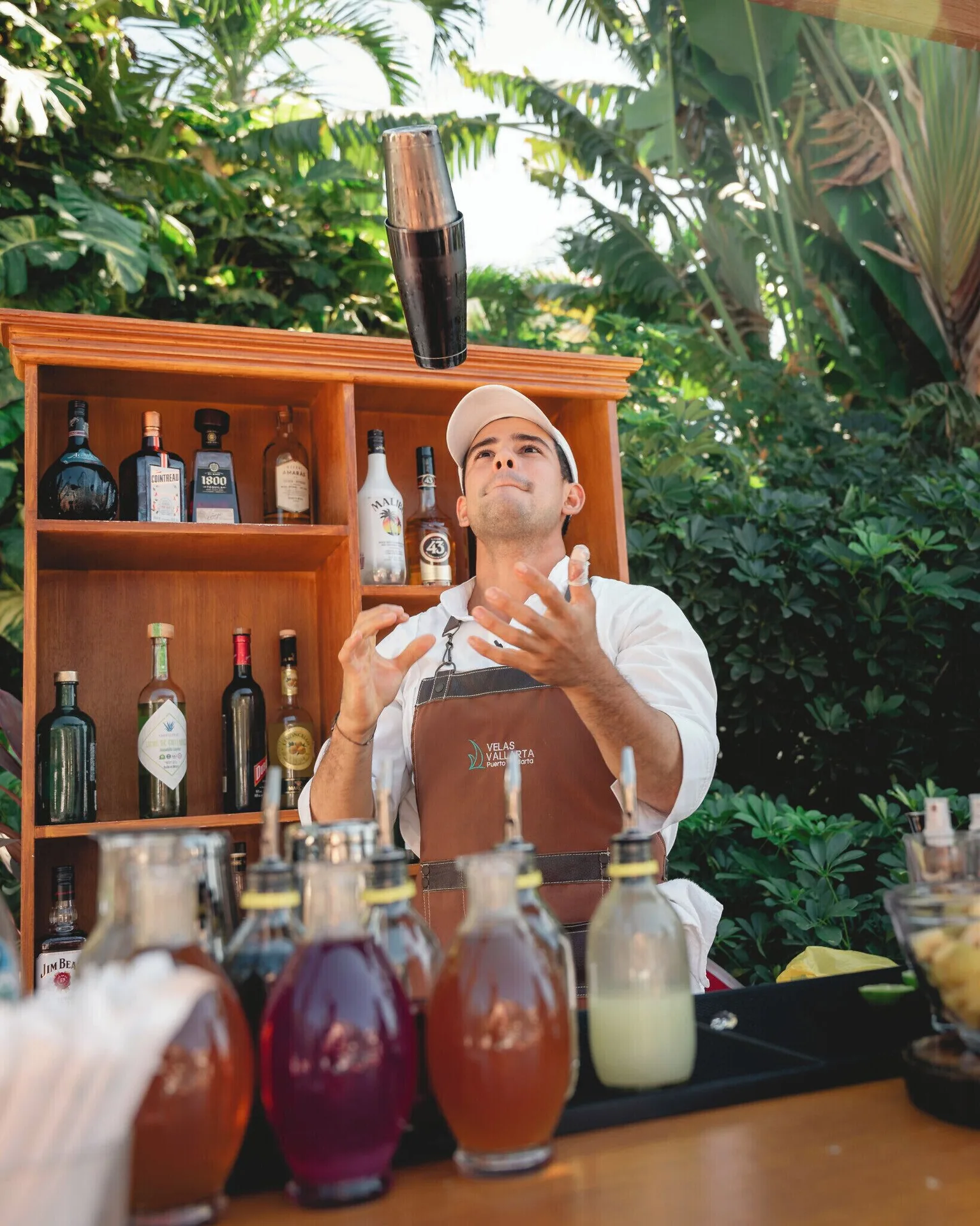 A bartender tosses a cocktail shaker at Velas Vallarta Suites Resort.