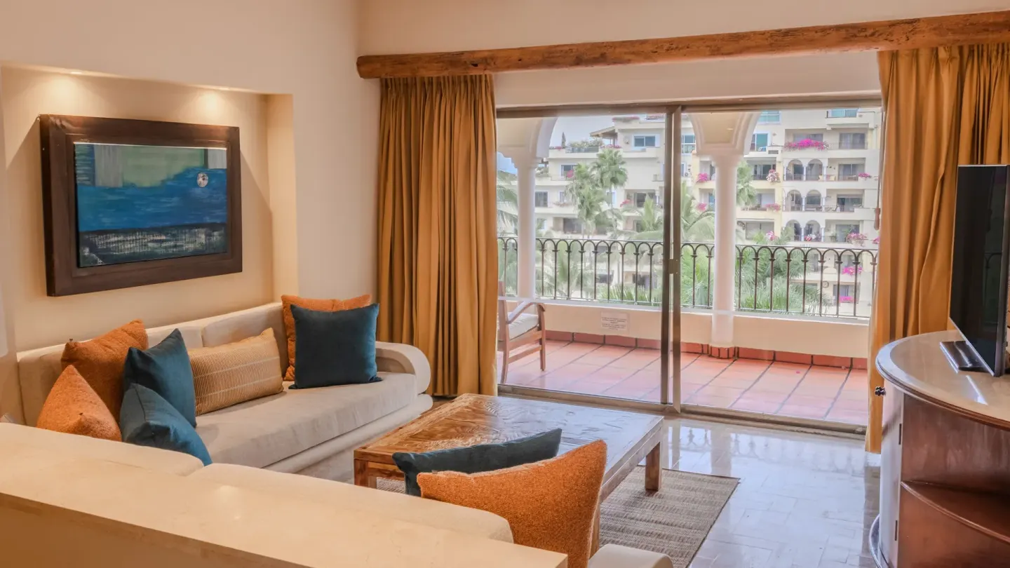 2 Bedroom Lock Off living area with sofa and balcony at Velas Vallarta Suites Resort.