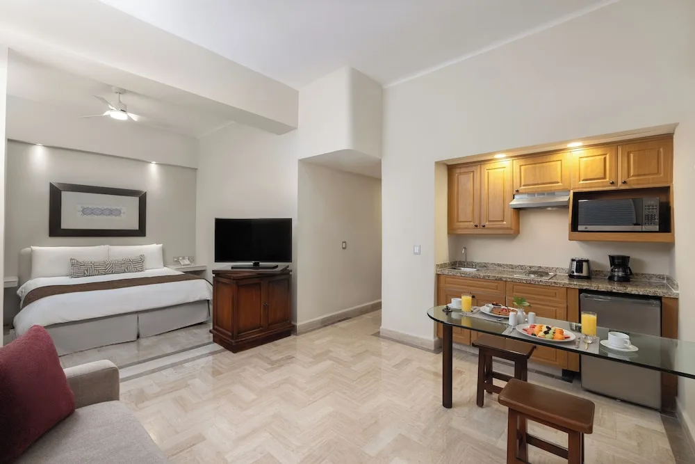 Deluxe Studio with bed, kitchenette and dining table at Velas Vallarta Suites Resort.