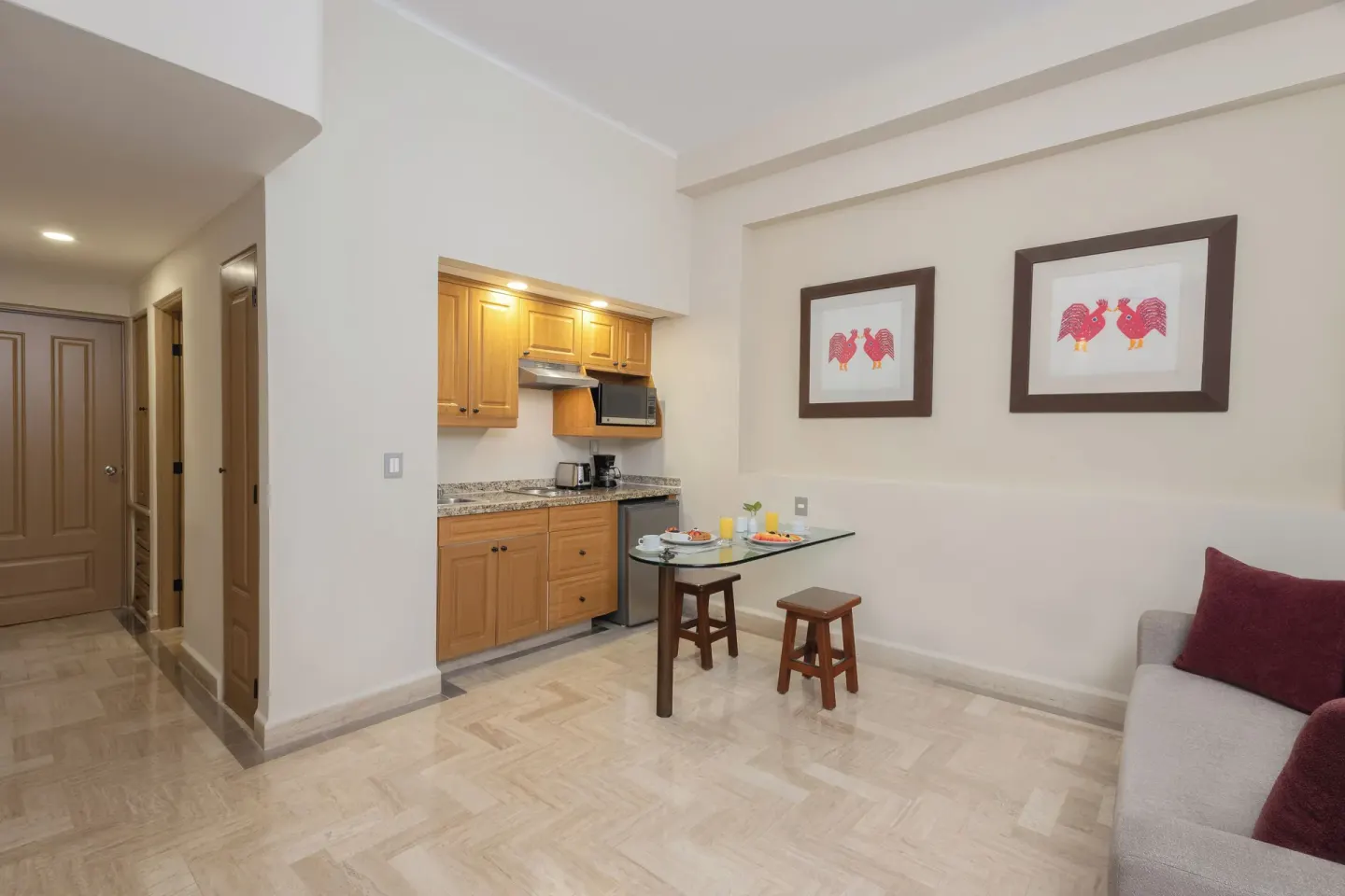 Deluxe Studio kitchenette and dining nook with sofa at Velas Vallarta Suites Resort.