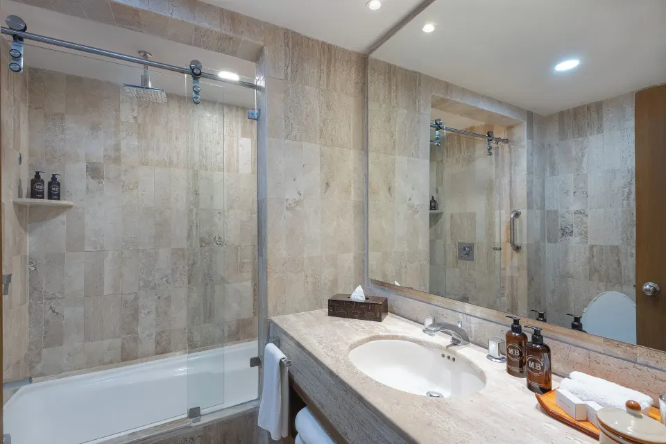 Deluxe Suite bathroom with tub shower and vanity at Velas Vallarta Suites Resort.